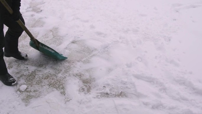 一个人在用铲子清理积雪。有选择性的重点。大自然。