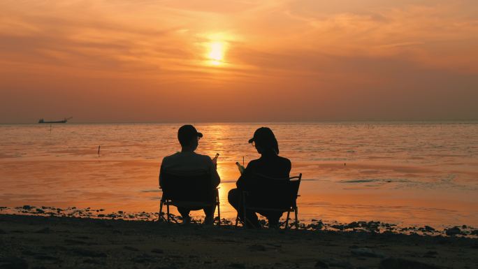 海边露营喝酒看日出日落夕阳黄昏