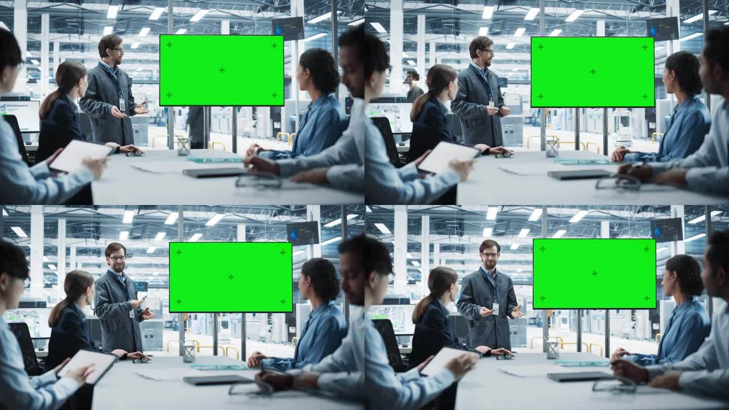 电子工厂办公室会议:白人工程师在电视上用绿屏Chromakey进行演示。不同的同事倾听微芯片的生产，