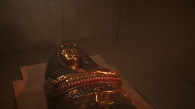 在一束光中，一个金色的木乃伊石棺躺在金字塔的一个墓室里