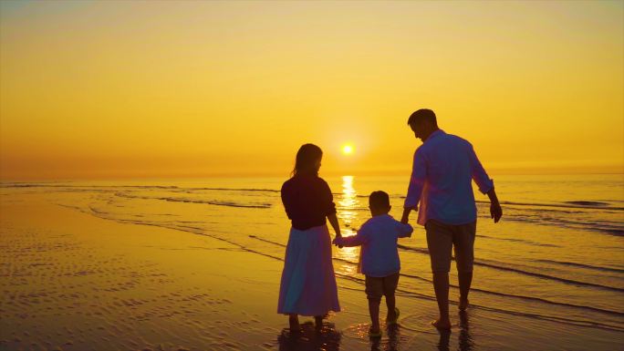 一家三口手牵手海滩慢步背影幸福温馨家庭