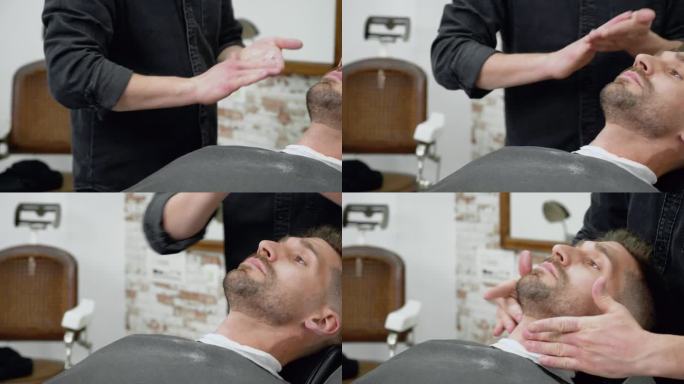 理发师在专业理发店给一个年轻人理发后，正在给他的胡子按摩和擦油。高品质4k画面