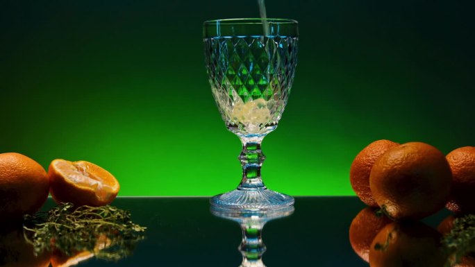 往杯子里倒橙汽水的特写。股票马蹄声。在反光的台面上，有柑橘和橙色水果味道的软饮料