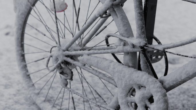 一辆停放的自行车在大雪中被雪覆盖。大城市里冬天的气氛。