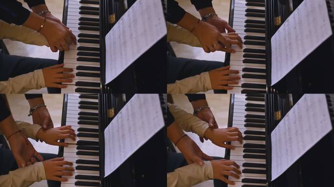 音乐家老师和男孩的手指触摸钢琴琴键，捕捉音乐的节奏，弹奏钢琴