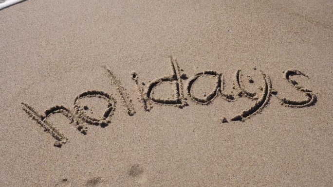海浪把沙滩上写的字——假日——冲走了。