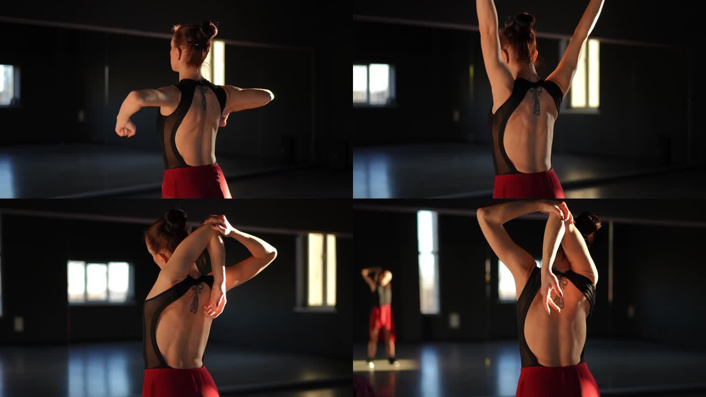 训练前热身。一名女子站在舞蹈教室的镜子前，通过旋转运动来热身她的肌肉。