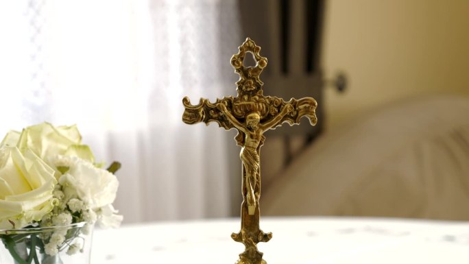 以新娘花束为背景的铜质装饰性十字架