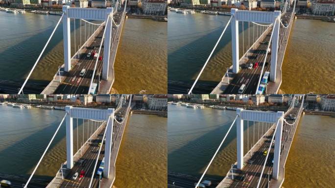 在阳光明媚的日子里，在布达佩斯城市景观的道贝河上伊丽莎白桥上移动的车辆的运动模糊无人机镜头