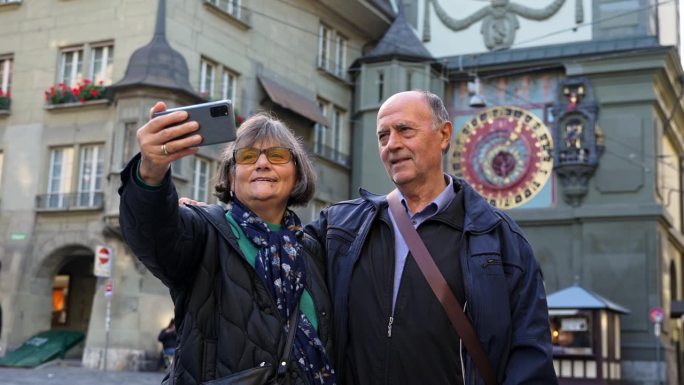 在伯尔尼的Zytglogge(钟楼)前自拍的老年游客夫妇