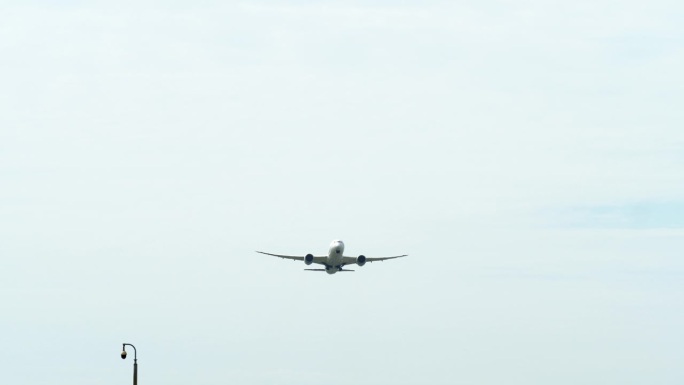 泰国机场，一架飞机在起飞时从其底部拍摄，露出蓝天和云彩。