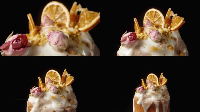 独立的复活节蛋糕，上面有白色的糖霜，装饰着橘子和花朵。多莉滑块极端特写。