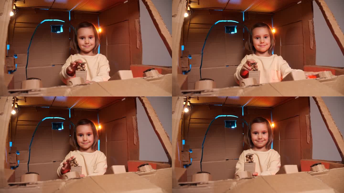 女孩控制着宇宙飞船。纸板飞船里的女孩