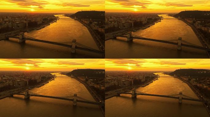 在匈牙利布达佩斯日落时分，多瑙河上的szacimchenyi链桥的空中无人机镜头映衬着戏剧性的天空