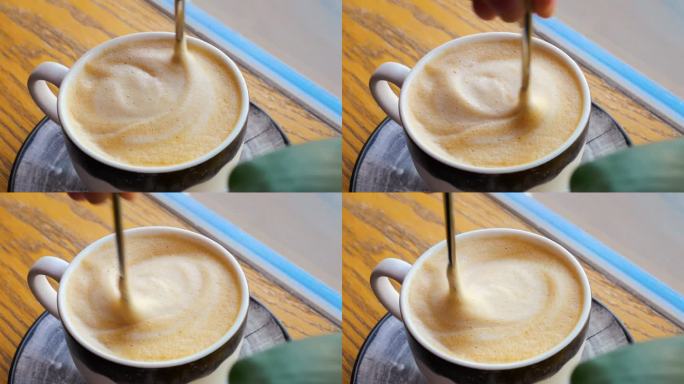 用手搅拌咖啡泡沫勺，注重健康的日常习惯。用心准备咖啡，健康方面享受清淡，泡沫覆盖的咖啡。健康意识的选