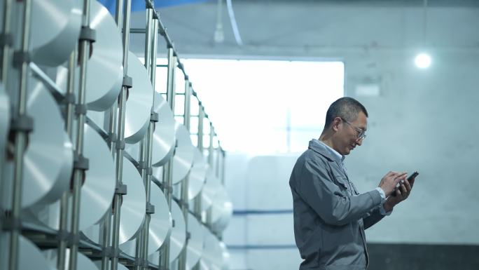 男性纺织工人化纤厂纺织厂生产车间使用手机