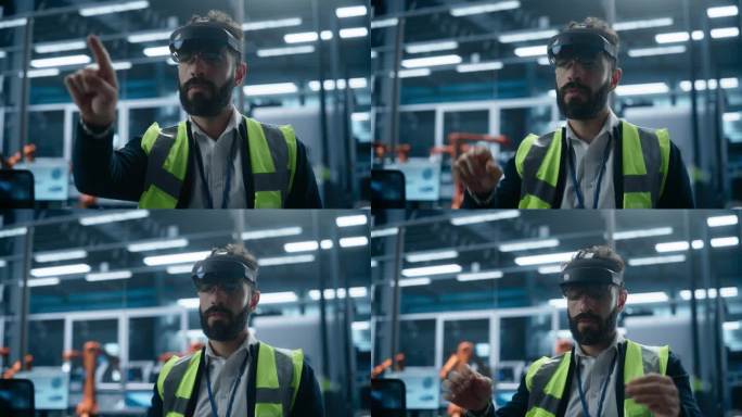 西班牙裔男性工业工程师坐在工厂办公室里，用增强现实耳机调节机械臂自动装配线。人的手势，使用未来的界面