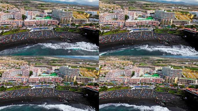 鸟瞰图的游客享受普拉亚德拉竞技场一个广受欢迎的海湾与广阔的黑沙延伸。