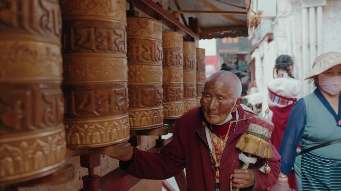 西藏诵经转经筒的藏民老人