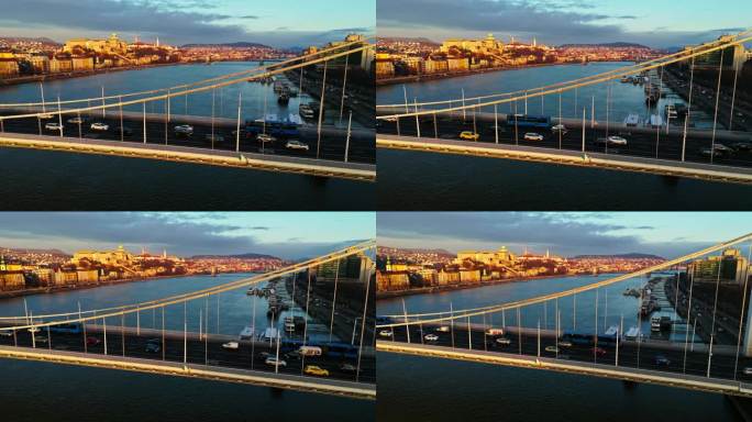 无人机镜头的汽车和公共汽车移动在多瑙河上的伊丽莎白桥在日落期间在布达佩斯，匈牙利