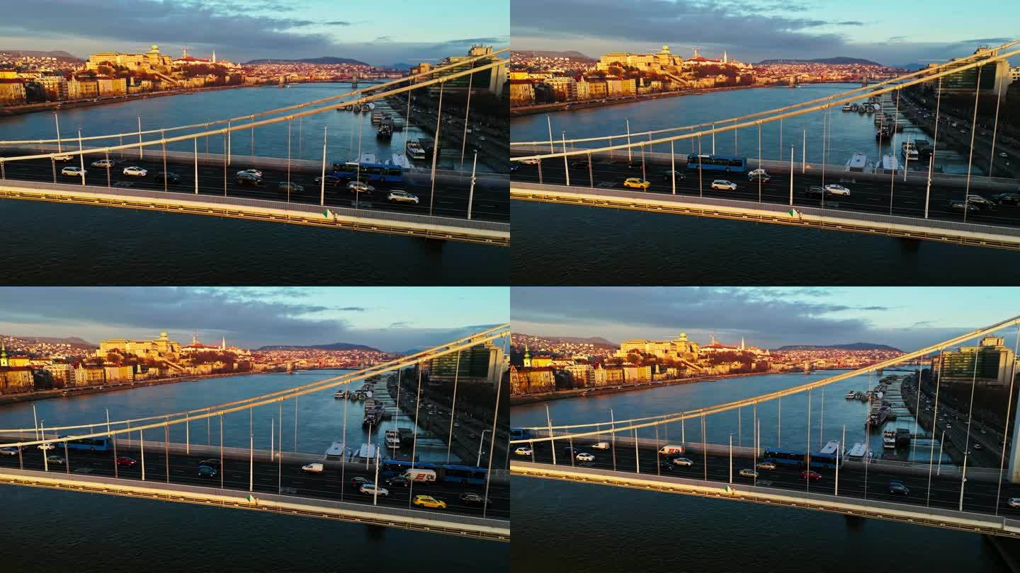 无人机镜头的汽车和公共汽车移动在多瑙河上的伊丽莎白桥在日落期间在布达佩斯，匈牙利