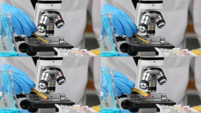 科学家化学家检查酸度的玻璃载玻片附近显微镜使用石碑试纸近距离4k电影慢镜头