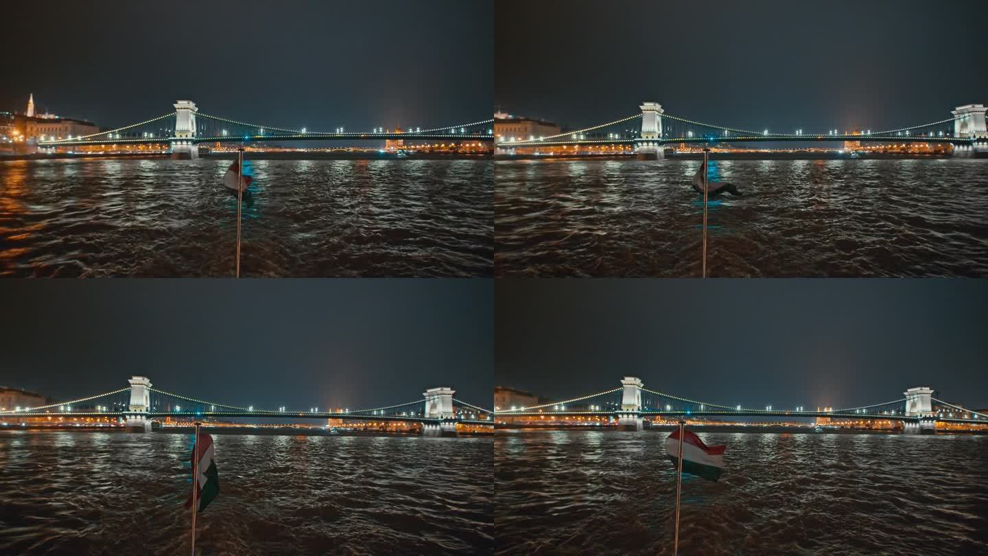 匈牙利，布达佩斯，多瑙河上从船的角度看匈牙利国旗，背景是被照亮的sz<s:1> chenyi链桥