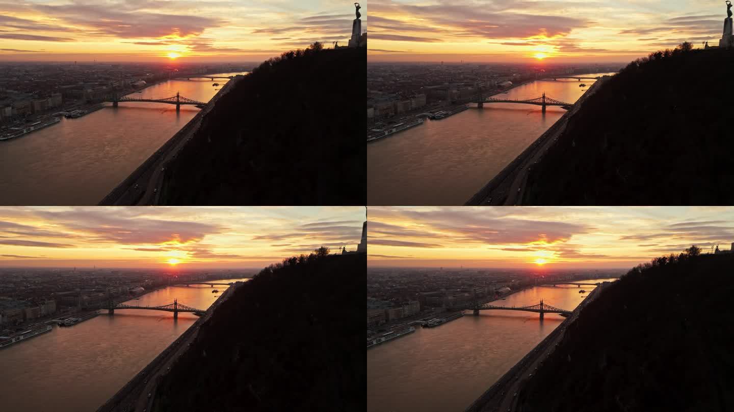 空中无人机拍摄的多瑙河上的自由桥在日落时分的城市剪影中，匈牙利布达佩斯