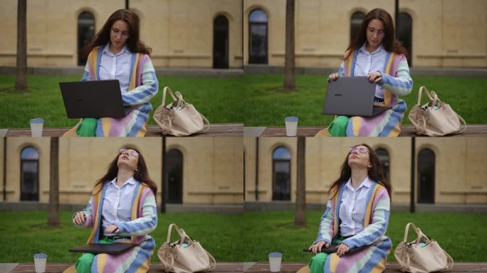 一位戴眼镜的美女，在笔记本电脑上敲完字，合上电脑，仰起头，松了口气。