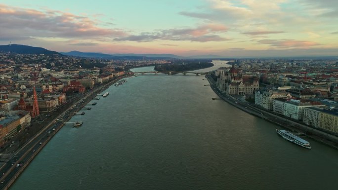 无人机拍摄的匈牙利议会大厦和多瑙河上拥挤的城市景观，在日落多云的天空，匈牙利布达佩斯