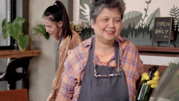 亚洲老人60多岁退休领取养老金的母亲和女儿快乐经营小餐馆，工人，服务员，咖啡师女清洁柜台酒吧咖啡厅咖
