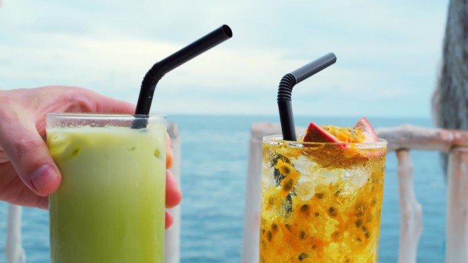 手摆鸡尾酒背景海，愉悦。享受，宁静的海边瞬间增添愉悦的清爽饮品。怡然自得的环境、元素、鸡尾酒的海洋，