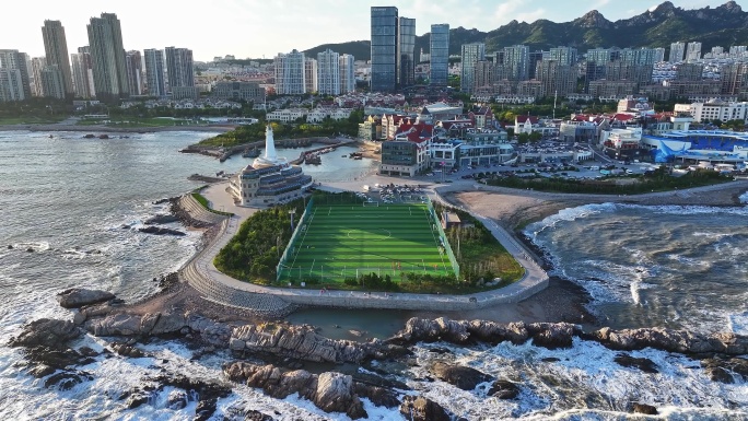 青岛城市白天海岸线足球场航拍