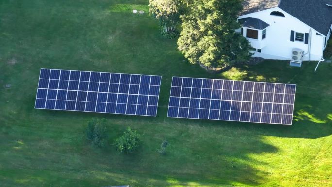 用于产生清洁生态电能的太阳能电池板安装在后院地面的独立框架上。自主住宅的概念