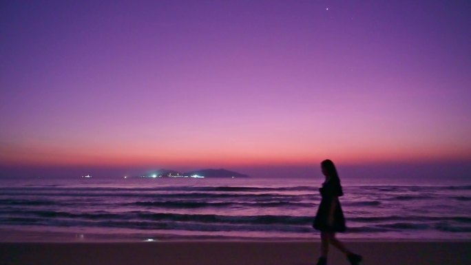 海南三亚海棠湾紫色天空漂亮美女在沙滩行走