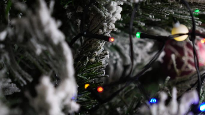 人造圣诞树上闪闪发光的花环特写，雪花模仿