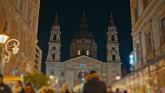 匈牙利布达佩斯，圣斯蒂芬大教堂外的圣诞树与市场上的人们在夜间的跟踪拍摄