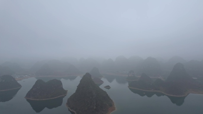 船舶在靖西渠洋湖平静的水面上喀斯特迷雾中