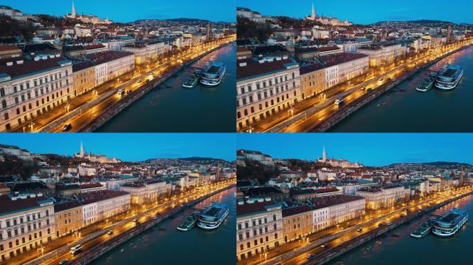 无人机镜头的游轮停泊在多瑙河上照亮城市景观的黄昏在布达佩斯，饥饿