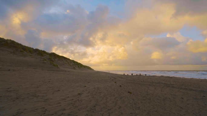 日落时分，天空下的沙滩和对比鲜明的云彩。静态照片