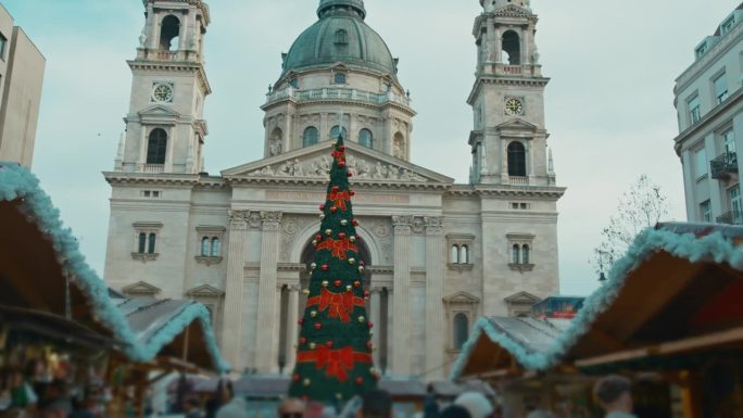 低角度手持拍摄的装饰圣诞树在市场外的圣斯蒂芬大教堂在布达佩斯，匈牙利