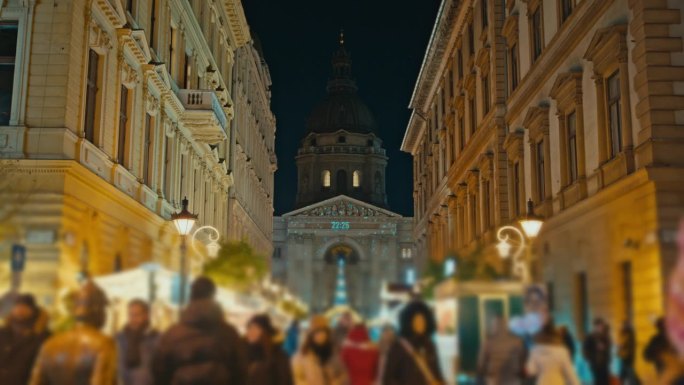 匈牙利布达佩斯圣斯蒂芬大教堂外的圣诞市场上人们夜间行走的跟踪镜头