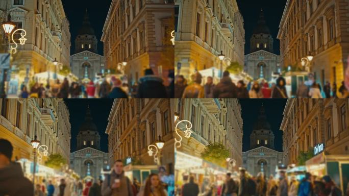 匈牙利布达佩斯圣斯蒂芬大教堂外的圣诞市场上人们夜间行走的跟踪镜头