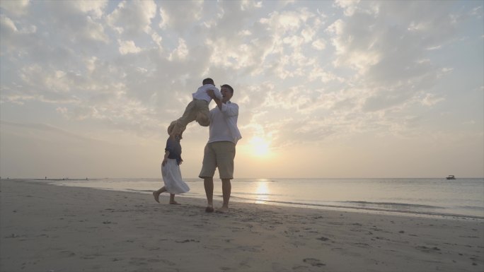 爸爸举起小孩幸福一家三口海边度假欢乐童年