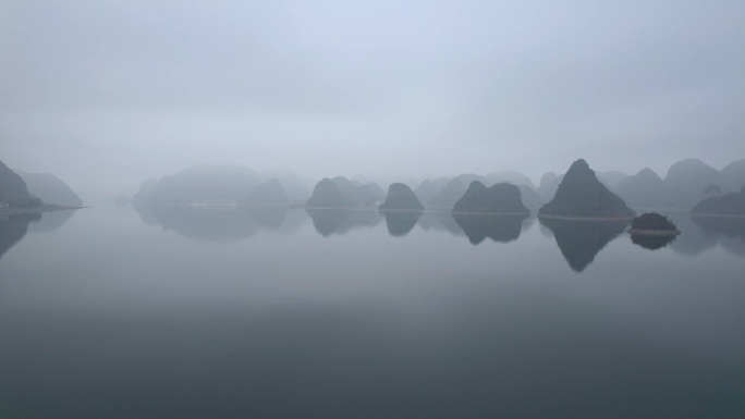 船舶在靖西渠洋湖平静的水面上喀斯特迷雾中