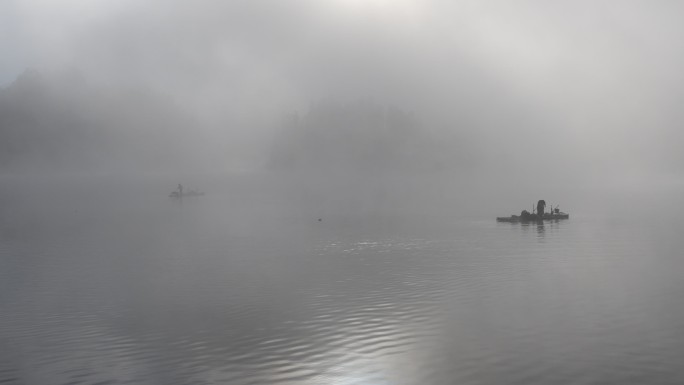 浓雾中的湖上打鱼人
