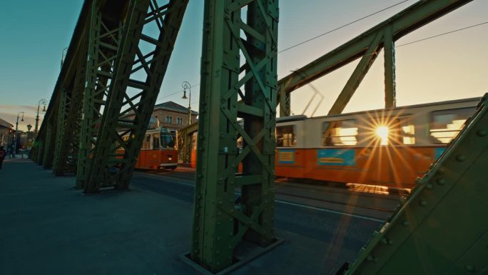 在阳光明媚的一天，匈牙利布达佩斯，有轨电车和汽车通过自由桥的手持照片