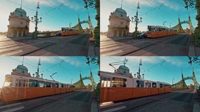手持拍摄的有轨电车和汽车通过自由桥在晴朗的日子对蓝天在布达佩斯，匈牙利