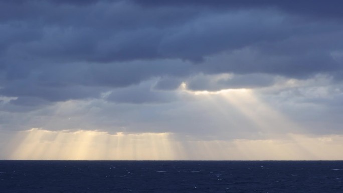 戏剧性的光线穿过海洋上的地平线上的风暴