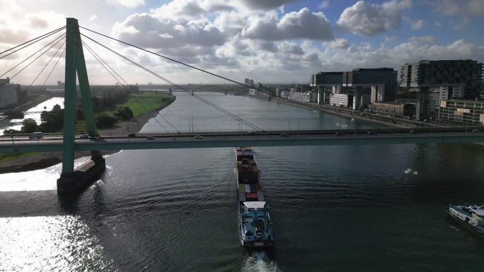 在德国科隆，一艘货轮载着集装箱在莱茵河上与塞维林大桥(severinsbrcke)和莱茵瑙哈芬港高速
